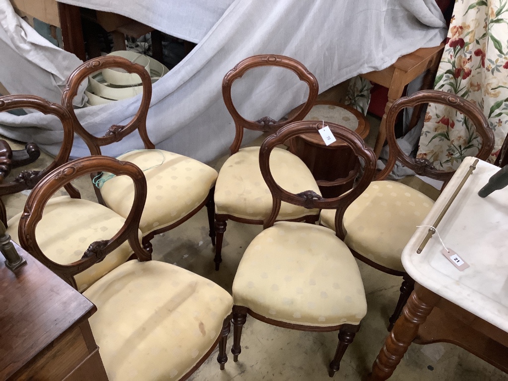 A set of six Victorian carved walnut balloon back dining chairs